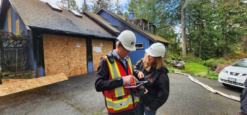Paige Foster and Derek Firth of Resolve Quantum reviewing plans at a job site